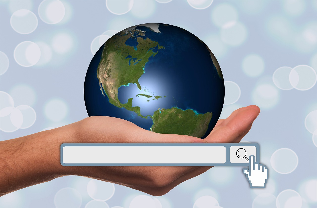 Hand holding a mini globe with a search bar depicting SEO services.